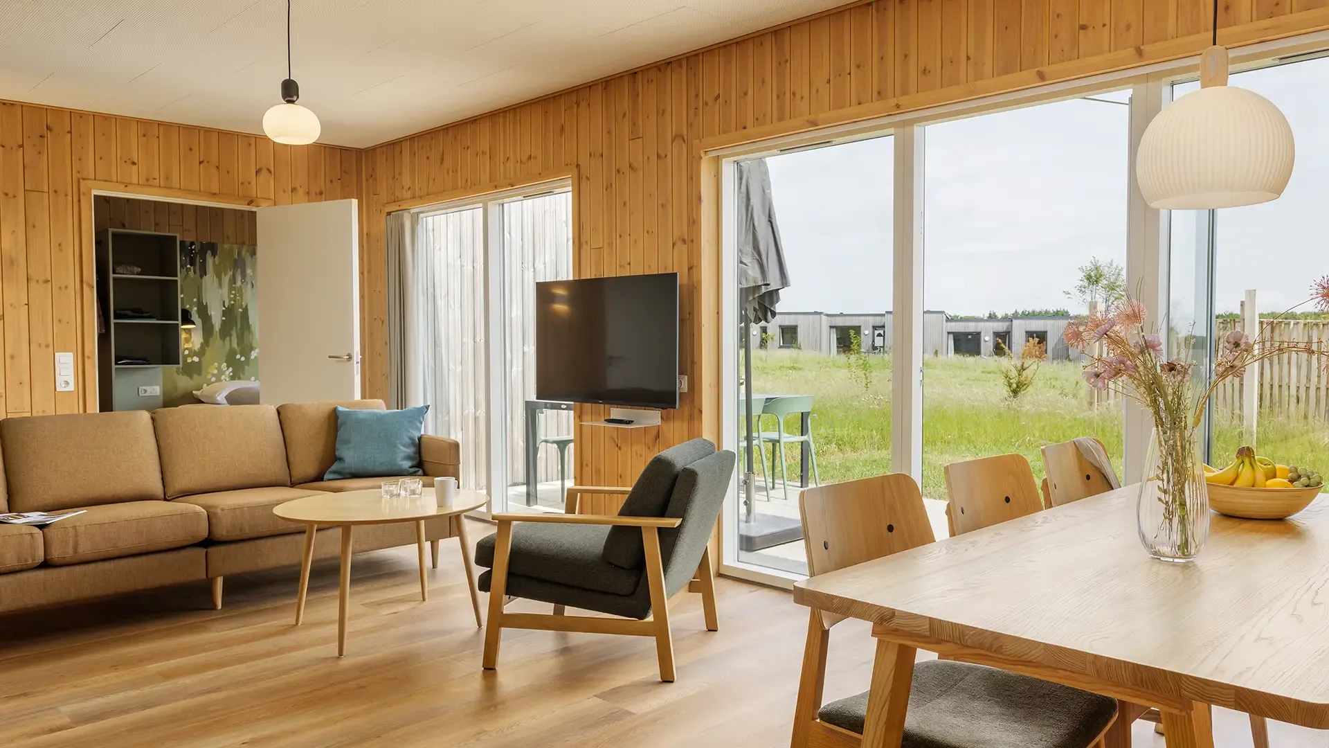 Living and dining area in a resort cabin featuring contract-grade seating and tables designed for durability and guest comfort at Nordborg Resort.