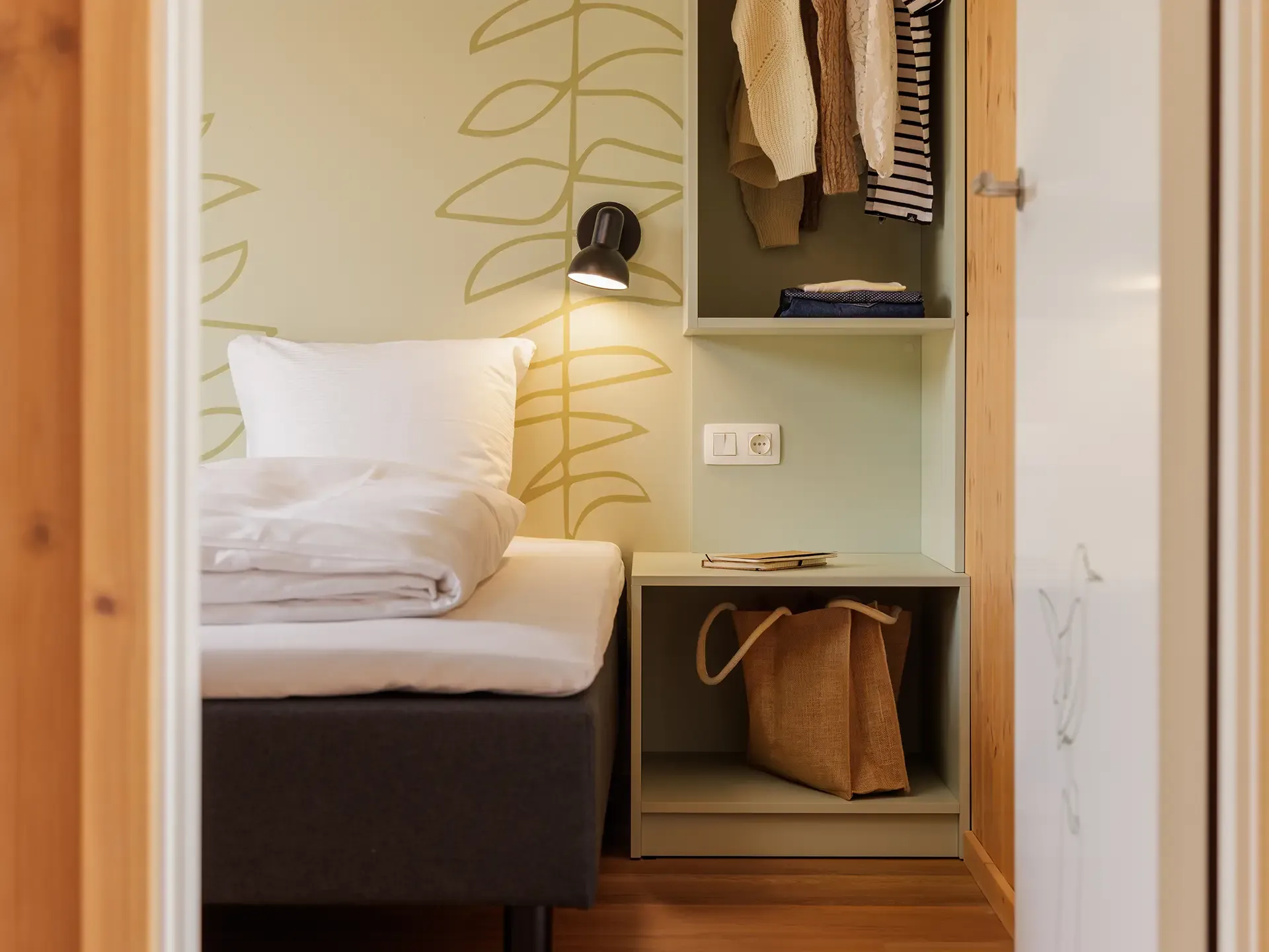 Close-up of bedroom storage and wardrobe solution with integrated lighting in a resort cottage at Nordborg Resort.