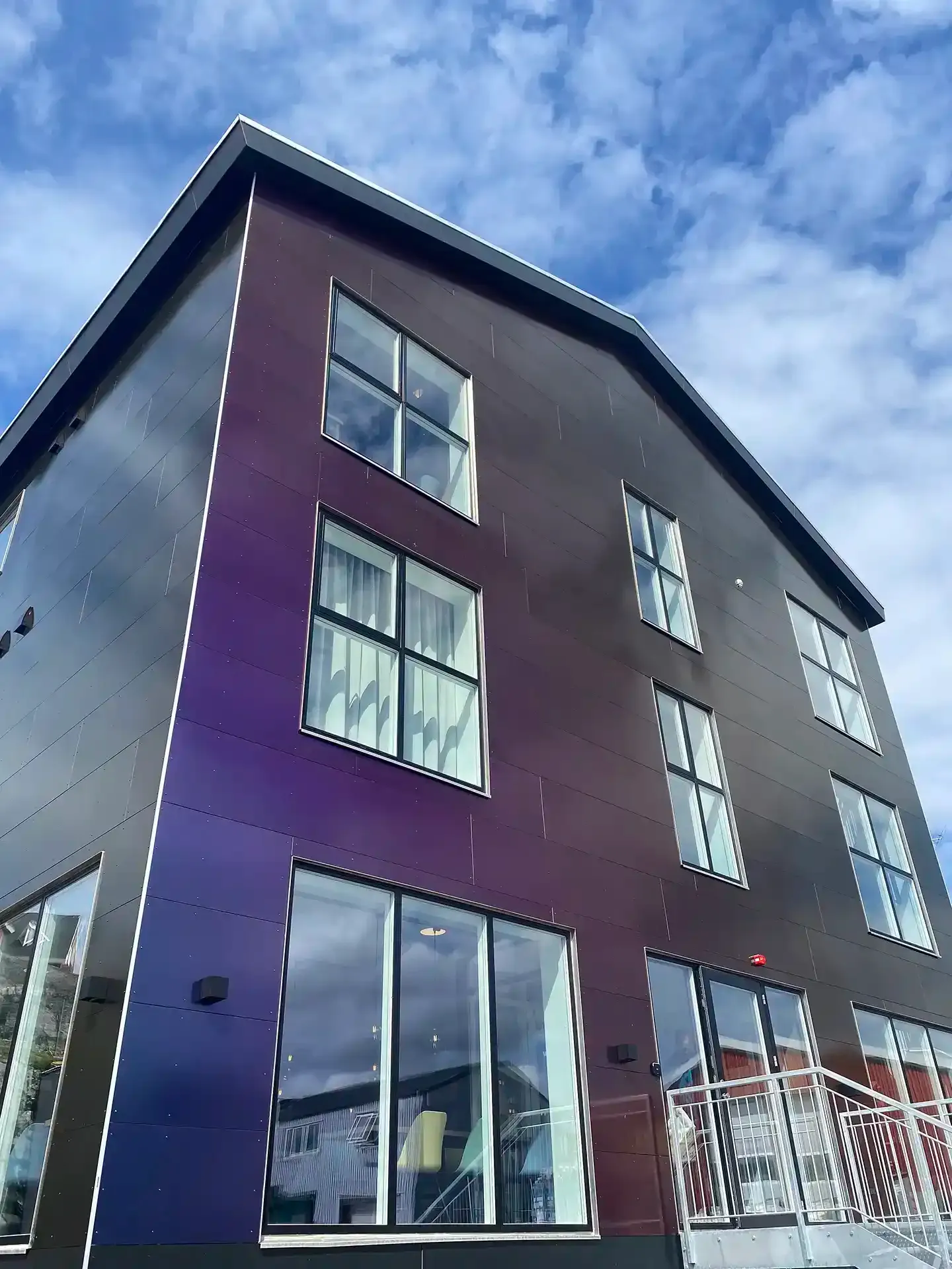 Modern hotel facade with large windows and colour-changing clatting
