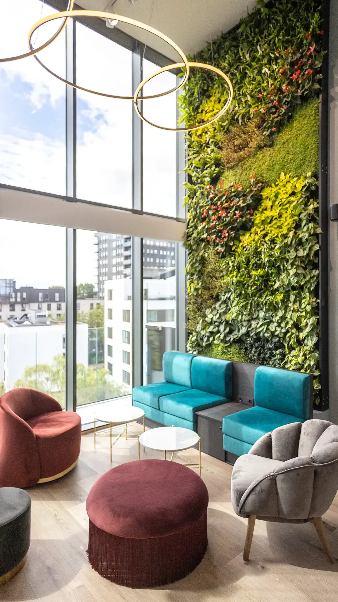 Hotel lounge seating area with green plant wall and modern furniture design.