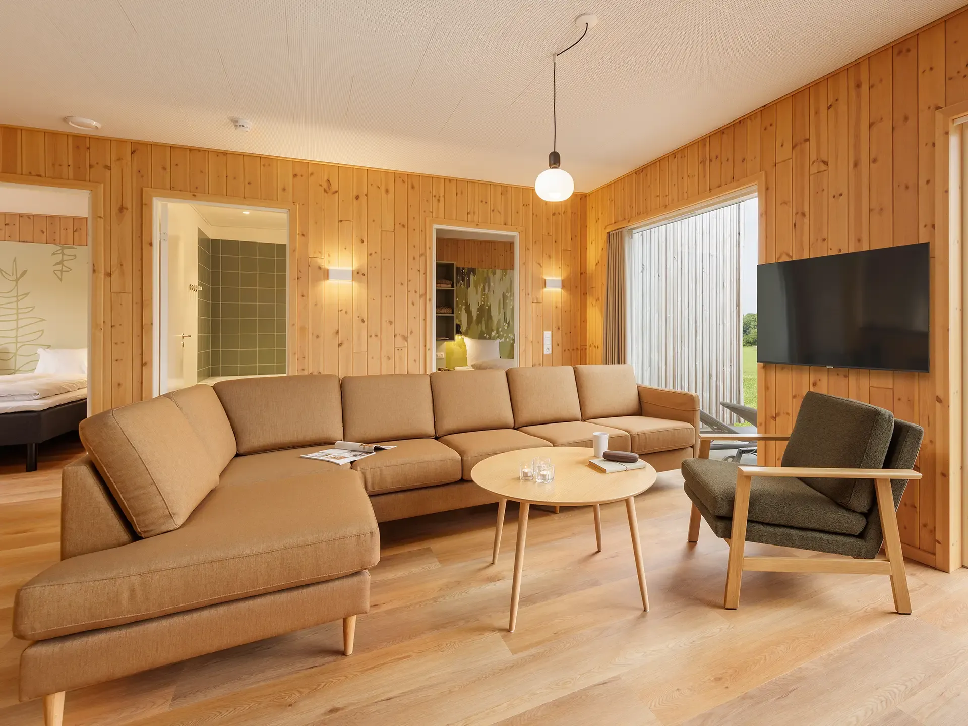 Soft seating and coffee table specified for durability and comfort in a resort cottage living area at Nordborg Resort.